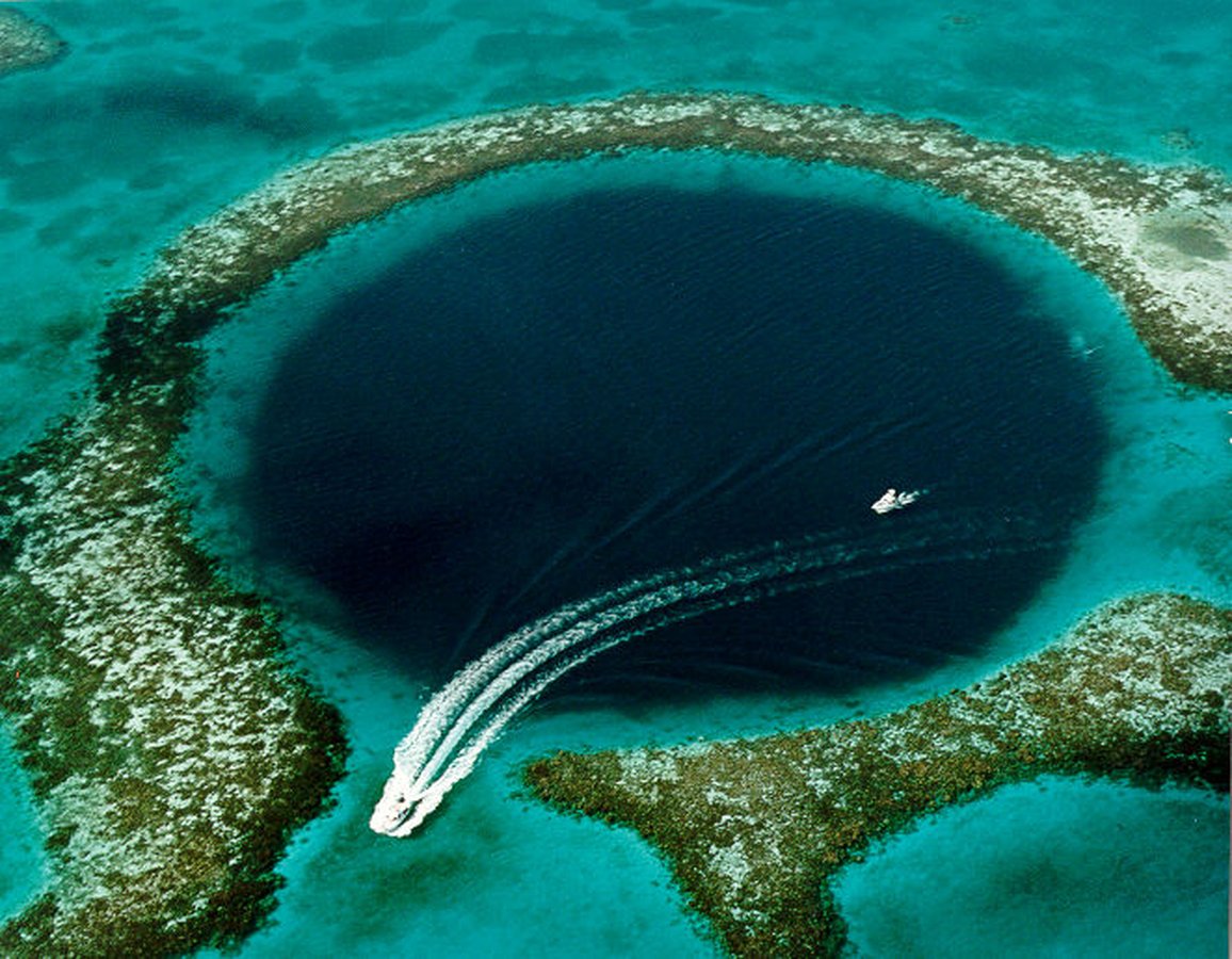 The Great Blue Hole off Belize’s coast, a giant marine sinkhole within the Belize Barrier Reef Reserve System, a UNESCO World Heritage Site.