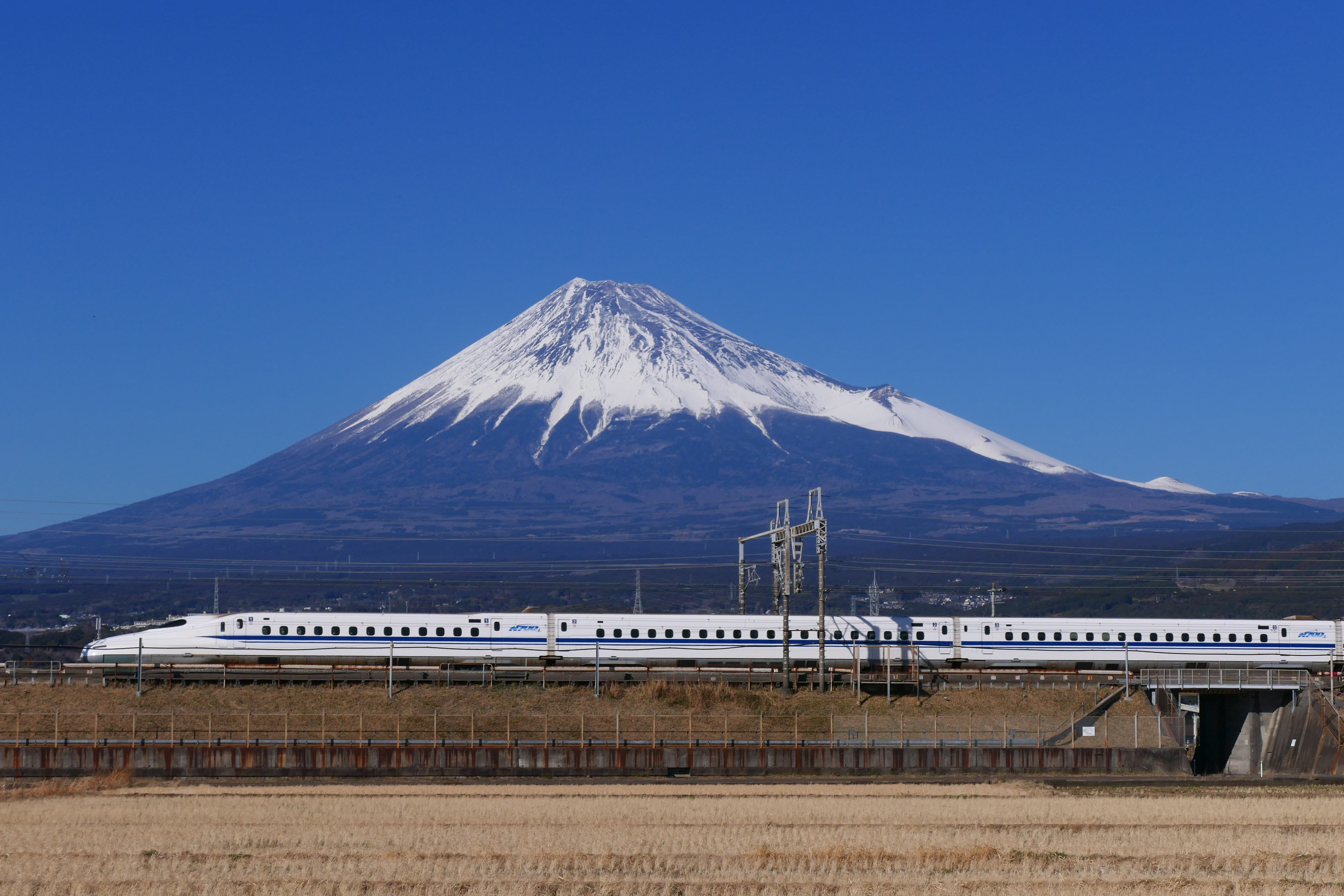The Tōkaidō Shinkansen passing with Mount Fuji in the background, an iconic symbol of Japan and its high-speed rail innovation.